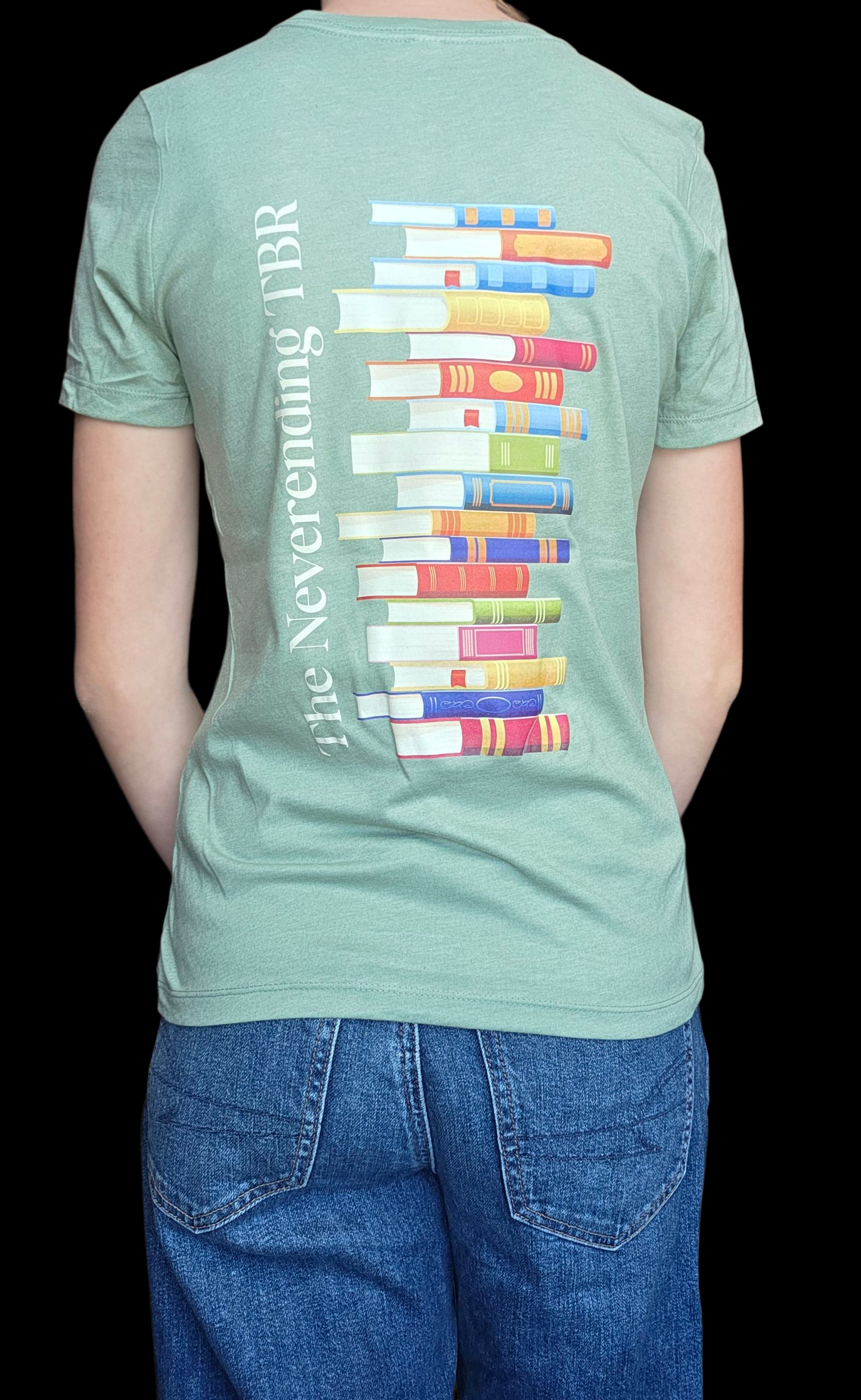 Person wearing a light green t-shirt with colorful book design and text on the back.
