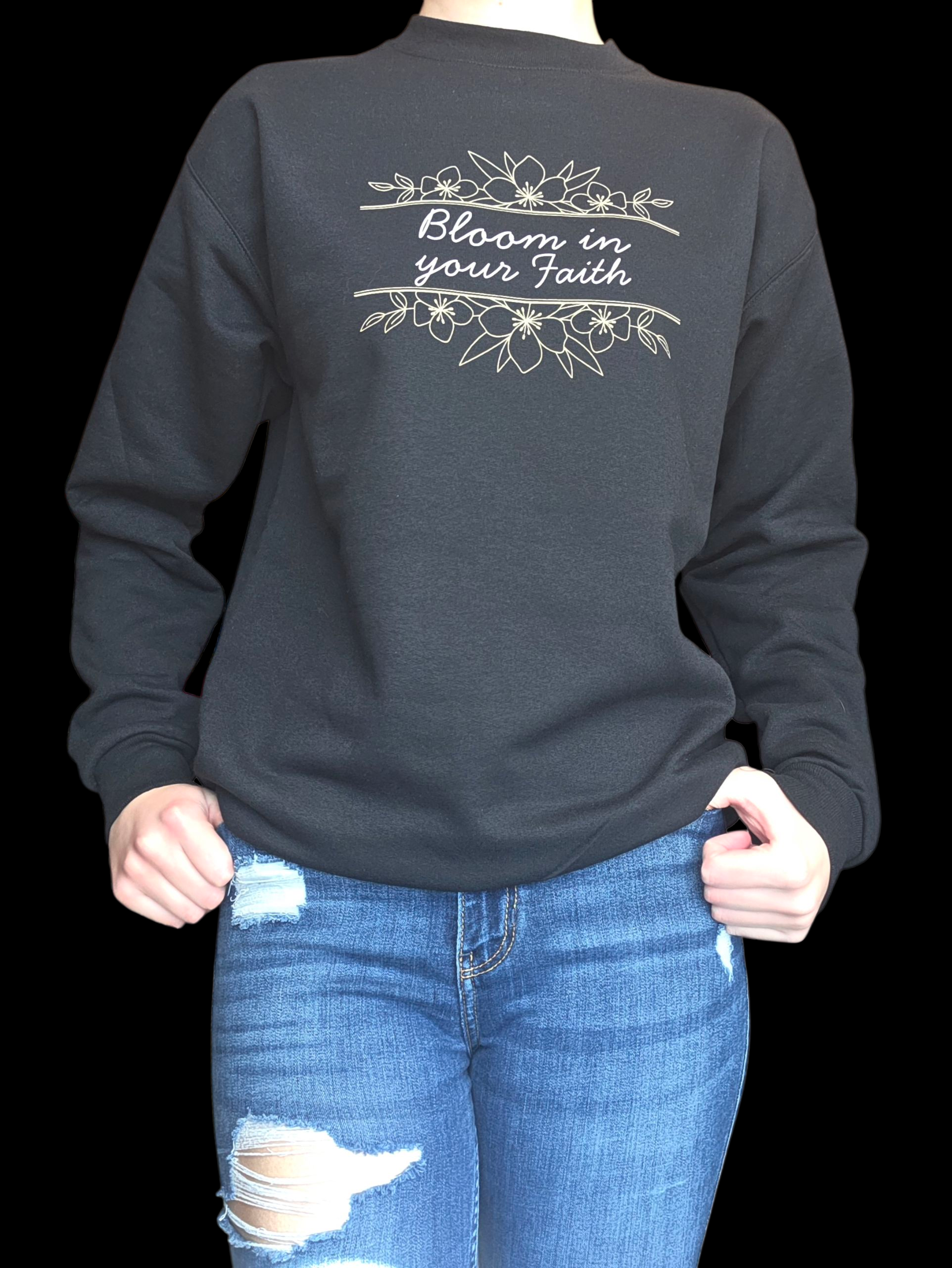Black crewneck with 'Bloom in your Faith' text and floral design on a black background.